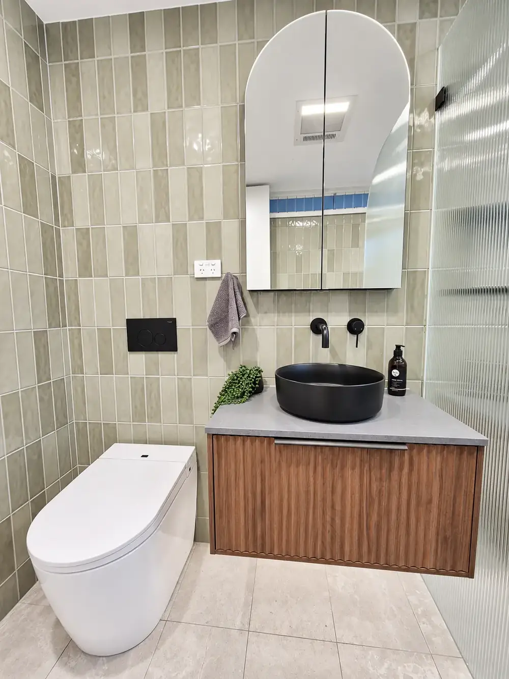 Chippendale main bathroom with green vertical tiles, arched mirror and timber vanity