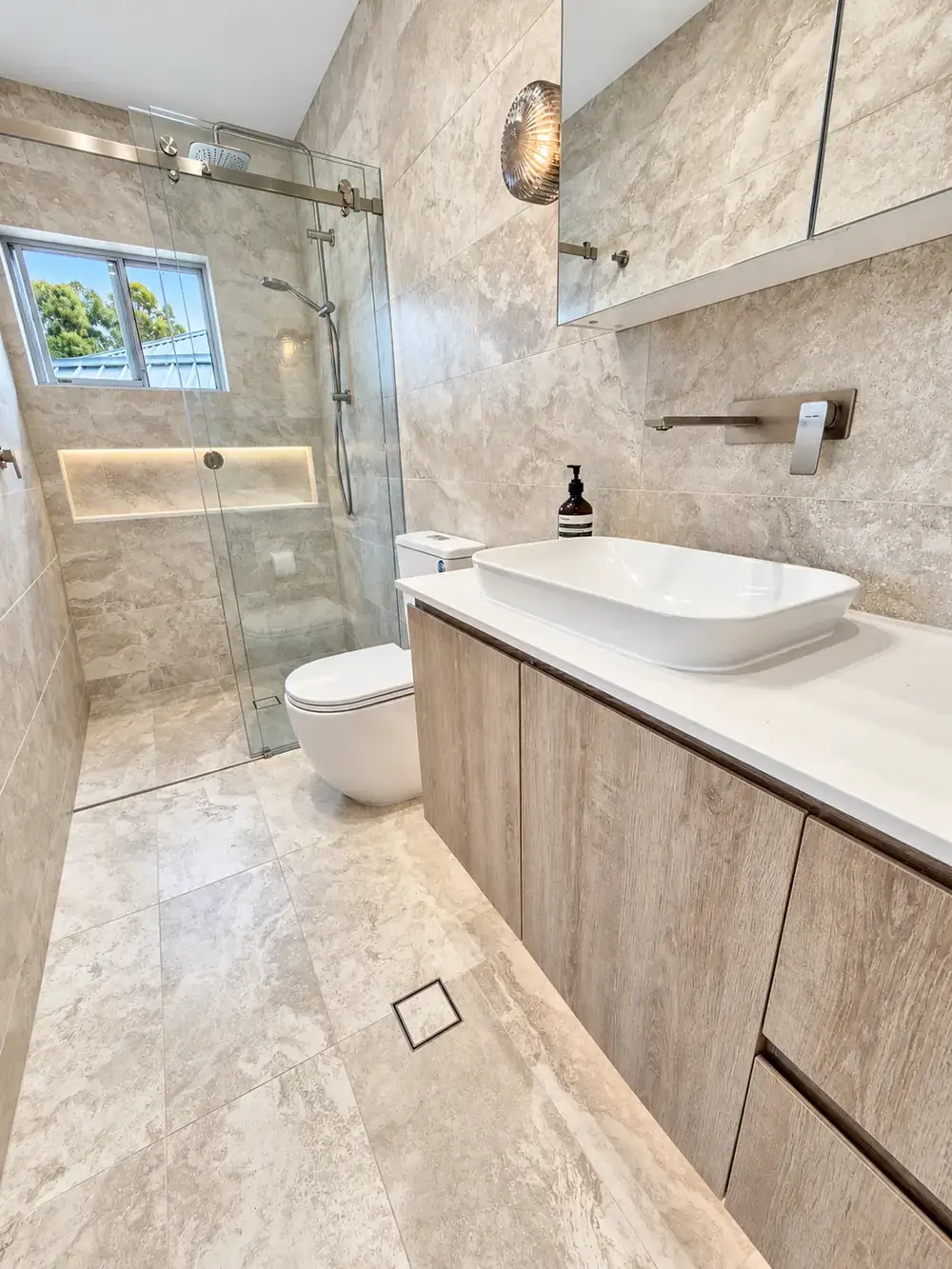 Jannali ensuite with travertine-look tiles, walk-in shower and timber vanity