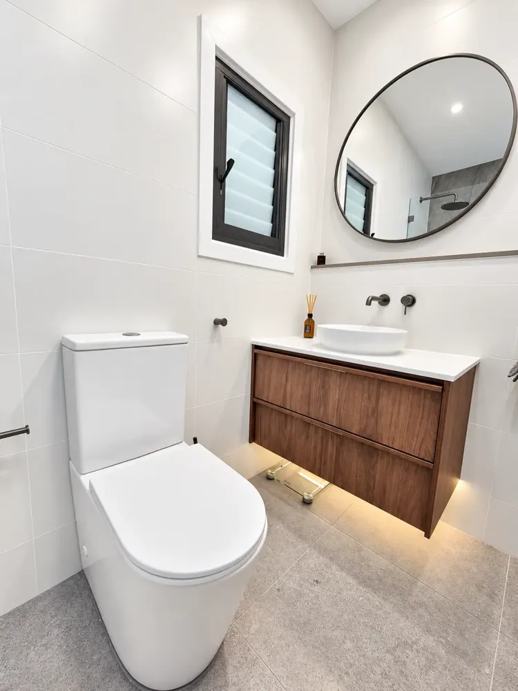 Marrickville bathroom with round black-framed mirror, vessel basin and floating walnut vanity