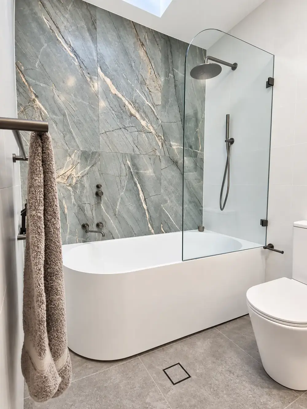Marrickville main bathroom with green marble feature wall and curved bath