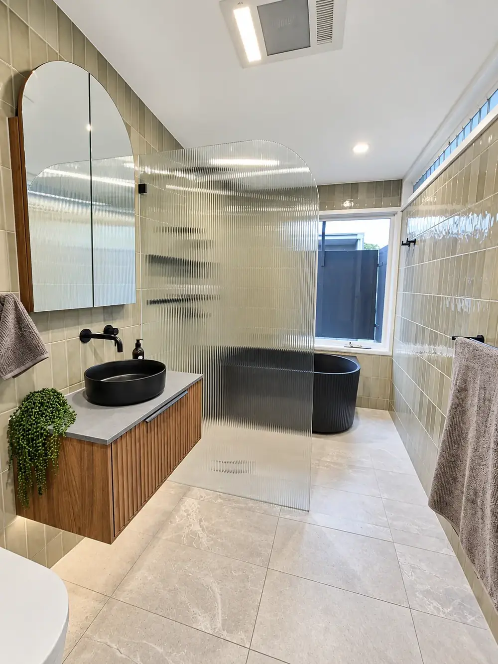 Chippendale bathroom with fluted glass screen and black freestanding bath